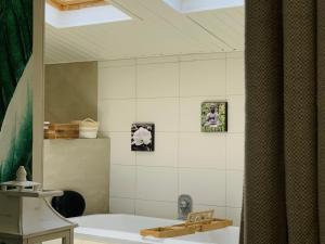 y baño con bañera y lavamanos. en Gîte Sallertaine, 2 pièces, 2 personnes - FR-1-426-470, en Sallertaine