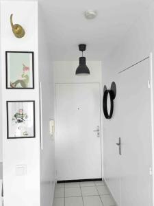 un corridoio bianco con una porta e immagini sul muro di Mickey's house - Apartments 4 persons - 10 min Disneyland Paris a Bussy-Saint-Georges