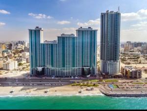 Blick auf eine Stadt mit Strand und Gebäuden in der Unterkunft Ocean View Luxury Suites in Ajman 