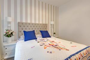 a bedroom with a large bed with blue pillows at Seaside Apartments Baltica Tower with Gym, Sauna & Parking in Gdańsk