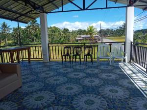 a patio with a table and chairs on a tile floor at La Veranda Farm Breeze in Batuan