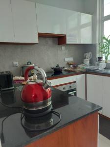 a red tea kettle on a counter in a kitchen at OESIS - Stylish Holiday Home in the heart of Galle in Galle