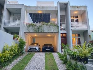 two cars parked in front of a house at OESIS - Stylish Holiday Home in the heart of Galle in Galle