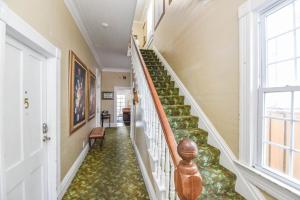 una escalera en una casa con alfombra verde en Curry House by Brightwild- 3rd Floor, King Bed, & Balcony Room 8, en Key West