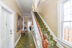 a staircase in a home with a green carpet at Curry House- 3rd Floor, King Bed, & Balcony Room 8 in Key West +13 photos