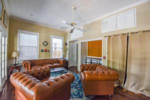 sala de estar con muebles de cuero y ventilador de techo en The Curry House - Entire Complex, en Key West
