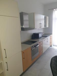 uma cozinha com armários brancos e um forno com placa de fogão em Montage em Wurzen