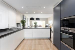 a kitchen with white cabinets and black appliances at Charming Marbella in Marbella