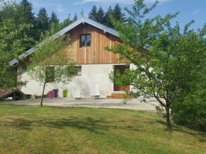 a house with two chairs and a tree at Gîte élégant en pleine nature avec terrasse, départ randonnées, parking privé et équipements inclus - FR-1-589-384 in Le Tholy