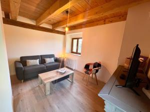 a living room with a couch and a table at Gîte élégant en pleine nature avec terrasse, départ randonnées, parking privé et équipements inclus - FR-1-589-384 in Le Tholy