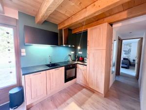 a kitchen with wooden cabinets and a sink at Gîte élégant en pleine nature avec terrasse, départ randonnées, parking privé et équipements inclus - FR-1-589-384 in Le Tholy