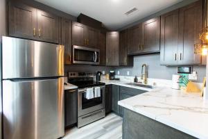 a kitchen with stainless steel appliances and wooden cabinets at Travel-Nurses & Professionals-Stay Close to it All in San Diego