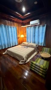 una camera con letto in una stanza con tende blu di ณ พรศุภะ เซรามิคคาเฟ่ 