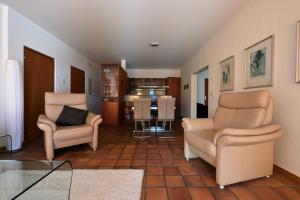 a living room with two chairs and a kitchen at Casa Serena in Arosa