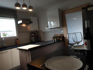 a kitchen with a bottle of wine and a wine glass at Happiness Cottage in Colmar