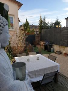 a statue sitting at a table in a backyard at Happiness Cottage in Colmar