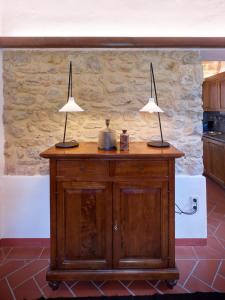 duas lâmpadas em cima de um armário de madeira numa cozinha em Agriturismo Podere Cortilla em Volterra