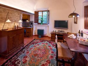 uma sala de estar com uma mesa e uma televisão em Agriturismo Podere Cortilla em Volterra