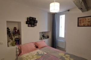 - une chambre avec un lit doté d'oreillers roses et d'une fenêtre dans l'établissement Appartement T2 de 40 m 2, neuf., aux Arcs-sur-Argens