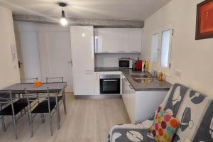 - une cuisine avec des placards blancs, une table et des chaises dans l'établissement Appartement T2 de 40 m 2, neuf., aux Arcs-sur-Argens