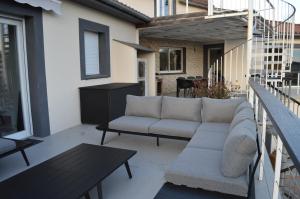 een patio met een bank en een tafel op een balkon bij La Tourelle du Lot in Cajarc