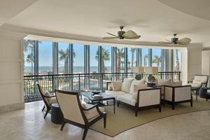 ガルベストンにあるPalisade Palms Oceanfront Condo & 5-Star Amenitiesのソファとテーブルと椅子のあるリビングルーム