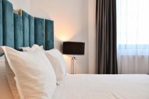 ein Schlafzimmer mit einem großen Bett mit weißen Kissen in der Unterkunft Hotel Building Stefan Resort I in Mamaia Nord – Năvodari