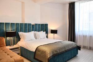 een slaapkamer met een groot bed en een bank bij Hotel Building Stefan Resort I in Mamaia Nord – Năvodari