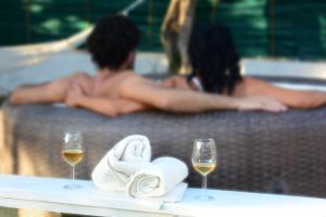 two people in a bathtub with two glasses of wine at Violisa Charme in Castellammare del Golfo