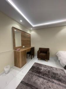 a bedroom with a desk and a bed and a mirror at استديوهات فاخرة in Ḑubā