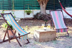 two chairs and a table with a bottle of wine at Violisa Charme in Castellammare del Golfo