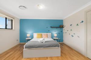 um quarto com uma cama grande e paredes azuis em Spacious Home With Lake Views em Lake Heights