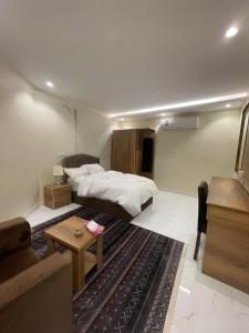 a bedroom with a bed and a living room at استديوهات فاخرة in Ḑubā