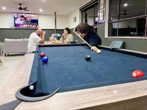 a group of people playing a game of snooker at Tiny House 10 at Grampians Edge in Dadswells Bridge