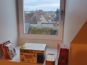 dos cajas sentadas en un estante junto a una ventana en Gîte Beaulieu-sur-Loire, 6 pièces, 10 personnes - FR-1-590-240, en Beaulieu-sur-Loire