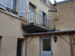 a building with a balcony and a door at Demeure restaurée avec chambres privatives, proche Loire, vignes et activités outdoor - FR-1-590-240 in Beaulieu-sur-Loire
