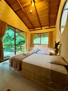 um quarto com uma cama grande num quarto com janelas em Wisdom Forest Lodge em Tena