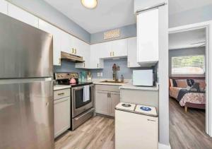 a kitchen with white cabinets and a stainless steel refrigerator at Stunning 1 BD 1BA In Naples in Naples