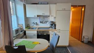 a small kitchen with a table and a table and chairs at Carmen's Ferienwohnung in Apelern