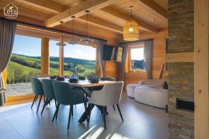 - une salle à manger avec une table, des chaises et un canapé dans l'établissement Lelu Spa&Natura, à Muszyna