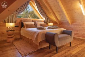 a bedroom with a bed and a chair and a window at Lelu Spa&Natura in Muszyna