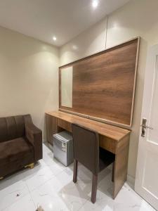 a desk in a room with a chair and a mirror at استديوهات فاخرة in Ḑubā