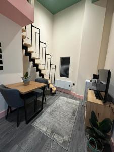 uma sala de jantar com uma mesa e uma escada em Cozy En-suite Loft in Trendy Local em Londres