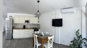 a kitchen with white cabinets and a table with chairs at EOS - Eforie Nord in Eforie Nord +26 photos