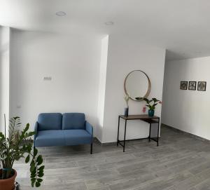 a blue couch in a room with a mirror at EOS - Eforie Nord in Eforie Nord