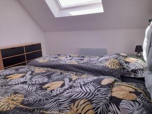 - une chambre avec 2 lits et un couvre-lit avec des feuilles dans l'établissement Gîte Corzé, 4 pièces, 6 personnes - FR-1-622-27, à Corzé