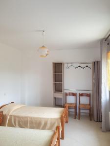 um quarto com 2 camas, uma mesa e cadeiras em Gîte les trois abeilles em Bésignan
