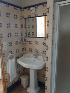 La salle de bains est pourvue d'un lavabo et d'un miroir. dans l'établissement B&B La Boissière Et Le Vialat, à Montagnac