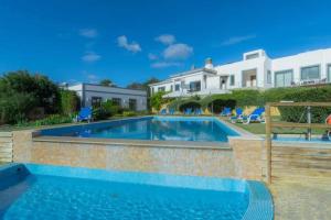 a swimming pool in front of a house at Villa Areias I - Beautiful landscape garden in Estói