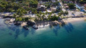 een luchtzicht op een strand met palmbomen en de oceaan bij Suítes Casa Maembippe in Ilhabela